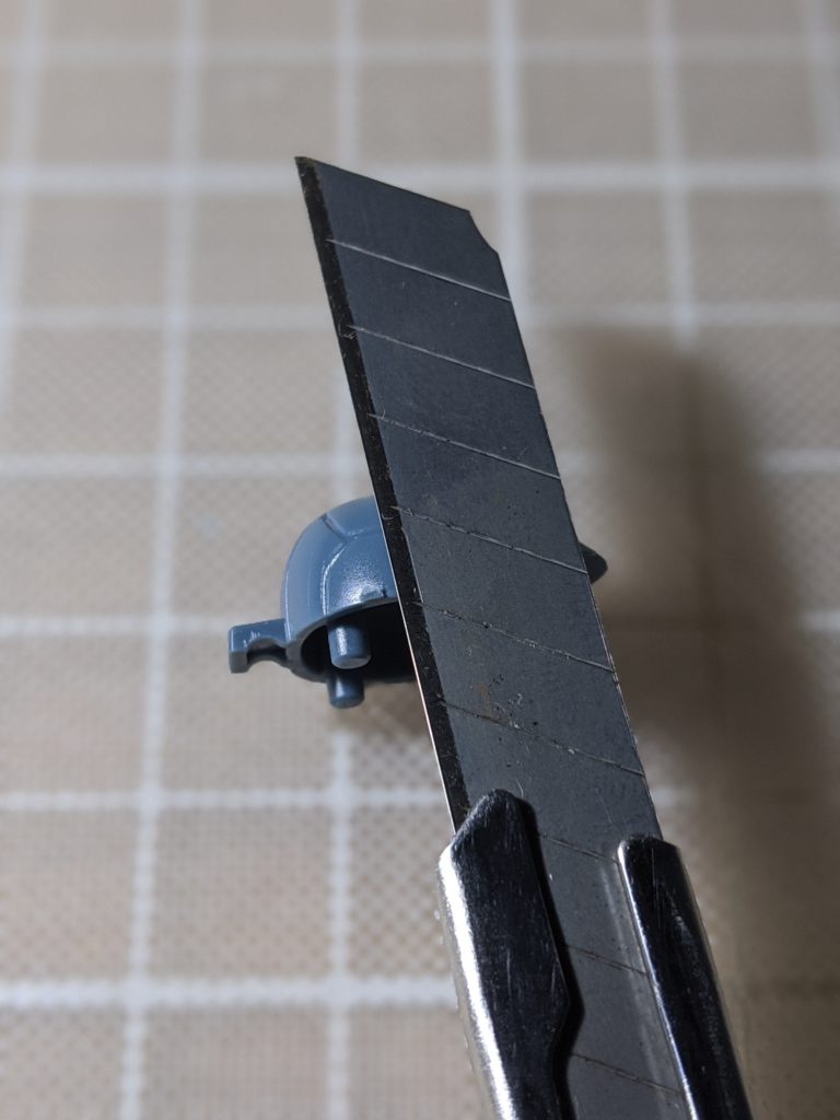 HG 1/144 高機動試作型ザク の頭部のゲート跡をカッターナイフで削る様子
