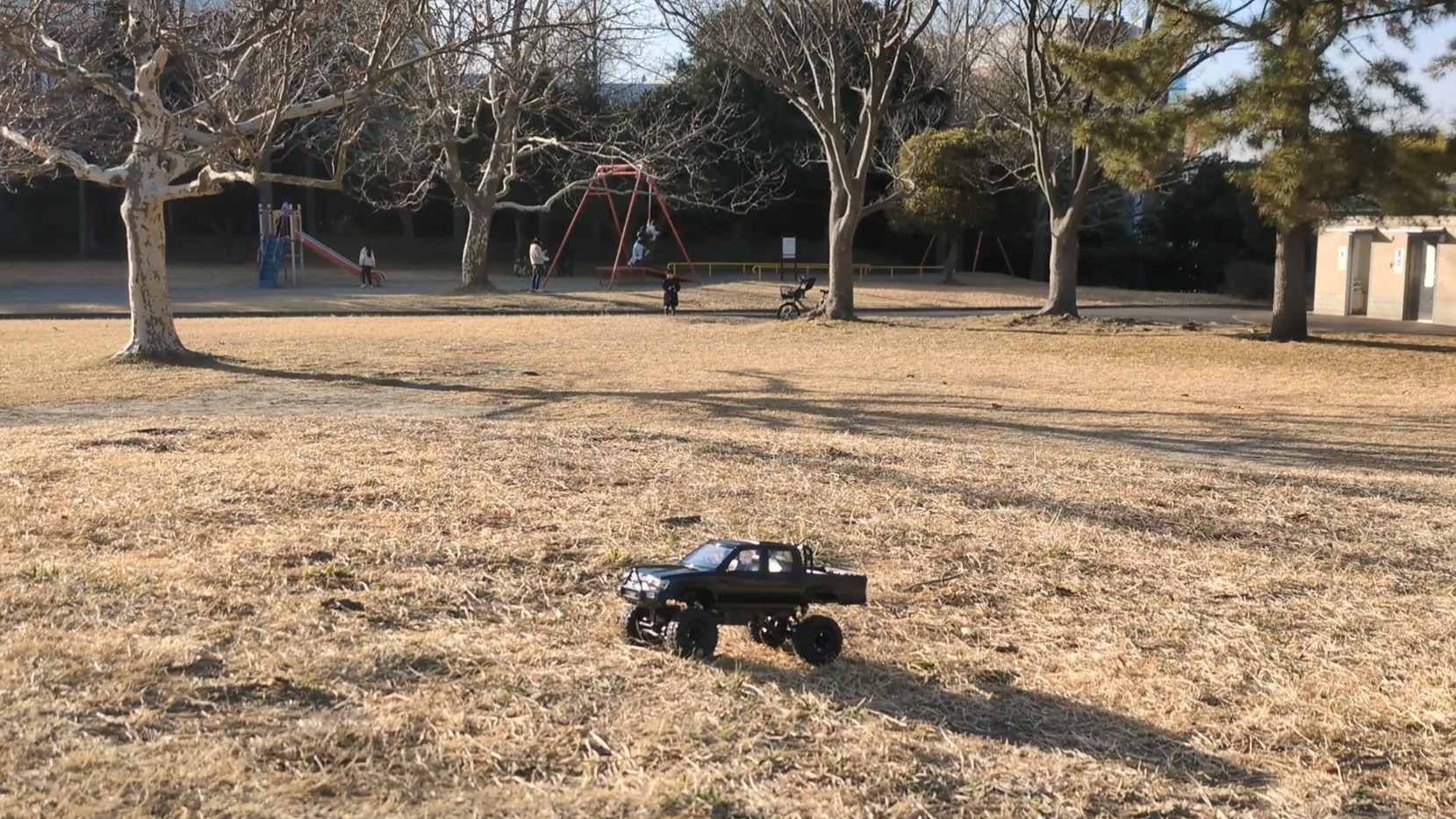 公園でラジコンカーを走らせる5歳児