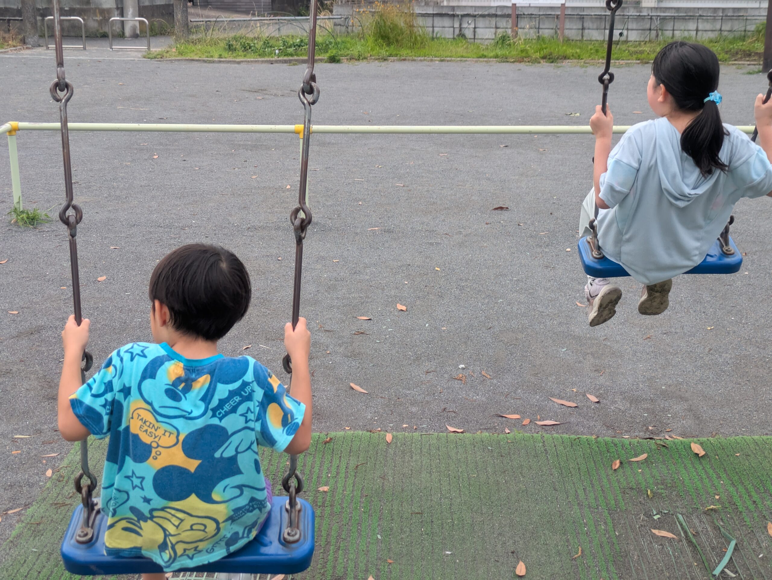 ブランコで遊ぶ6歳児と10歳児